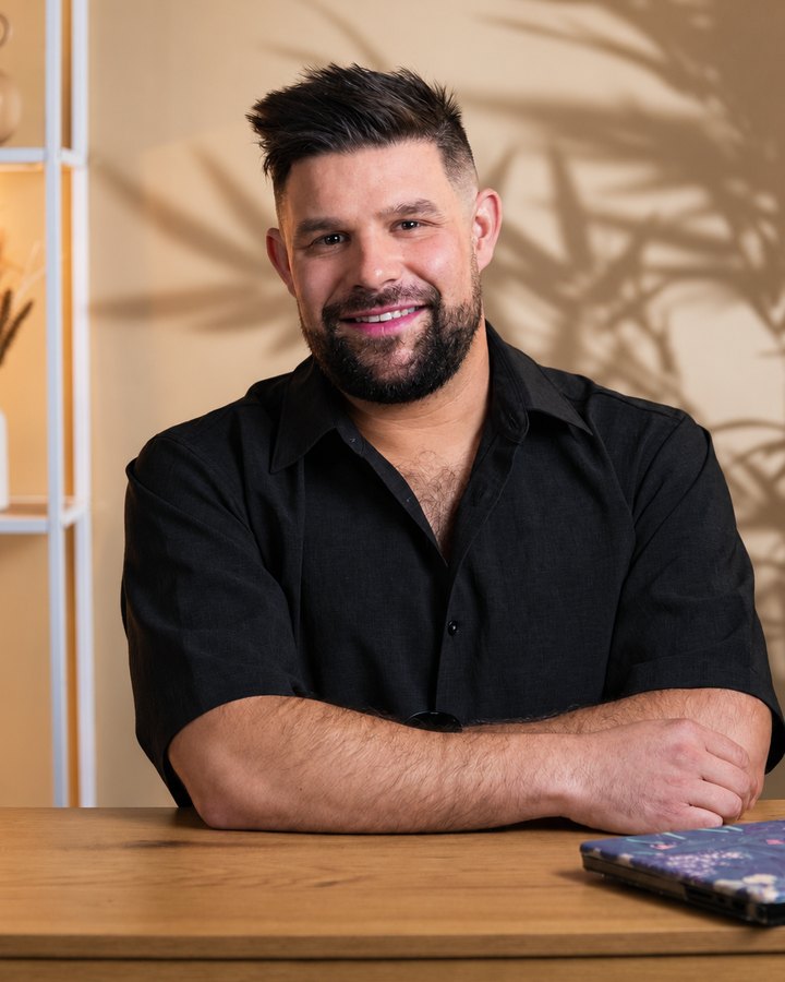 Sylvain, les bras croisés sur son bureau, un léger sourire.