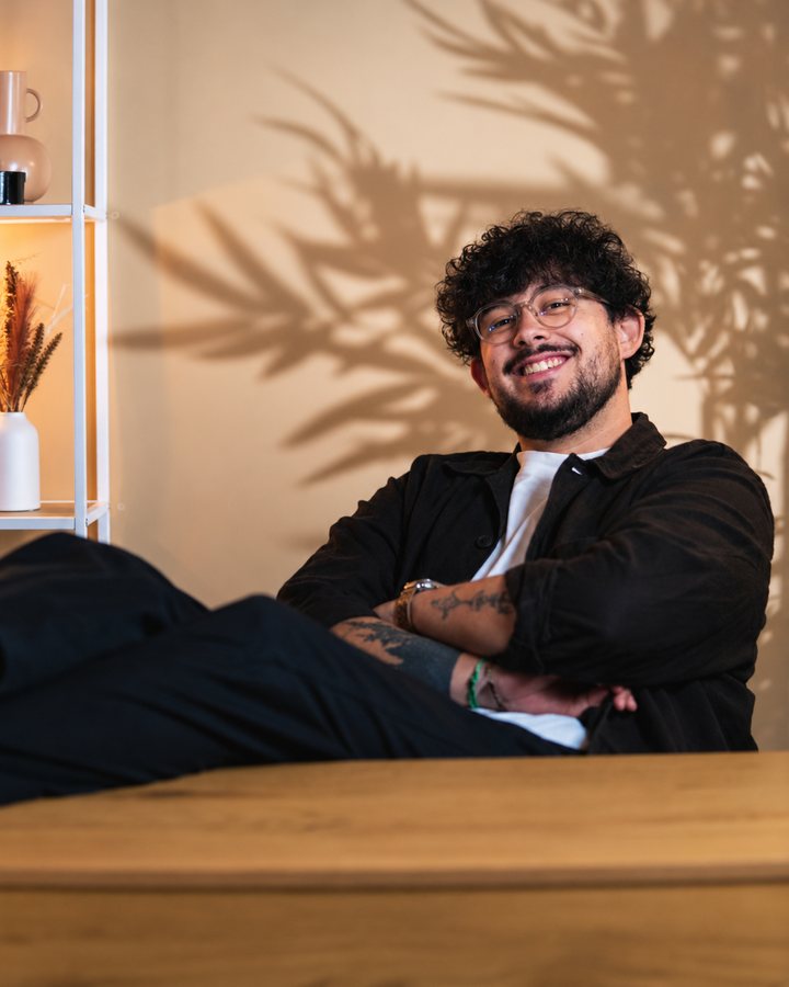 Tom, renversé dans sa chaise, les jambes sur le bureau et les bras croisés.