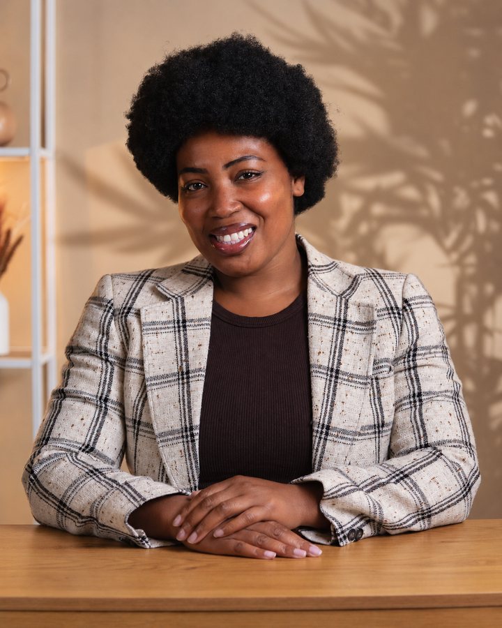 Yasmine, souriante, assise à son bureau.